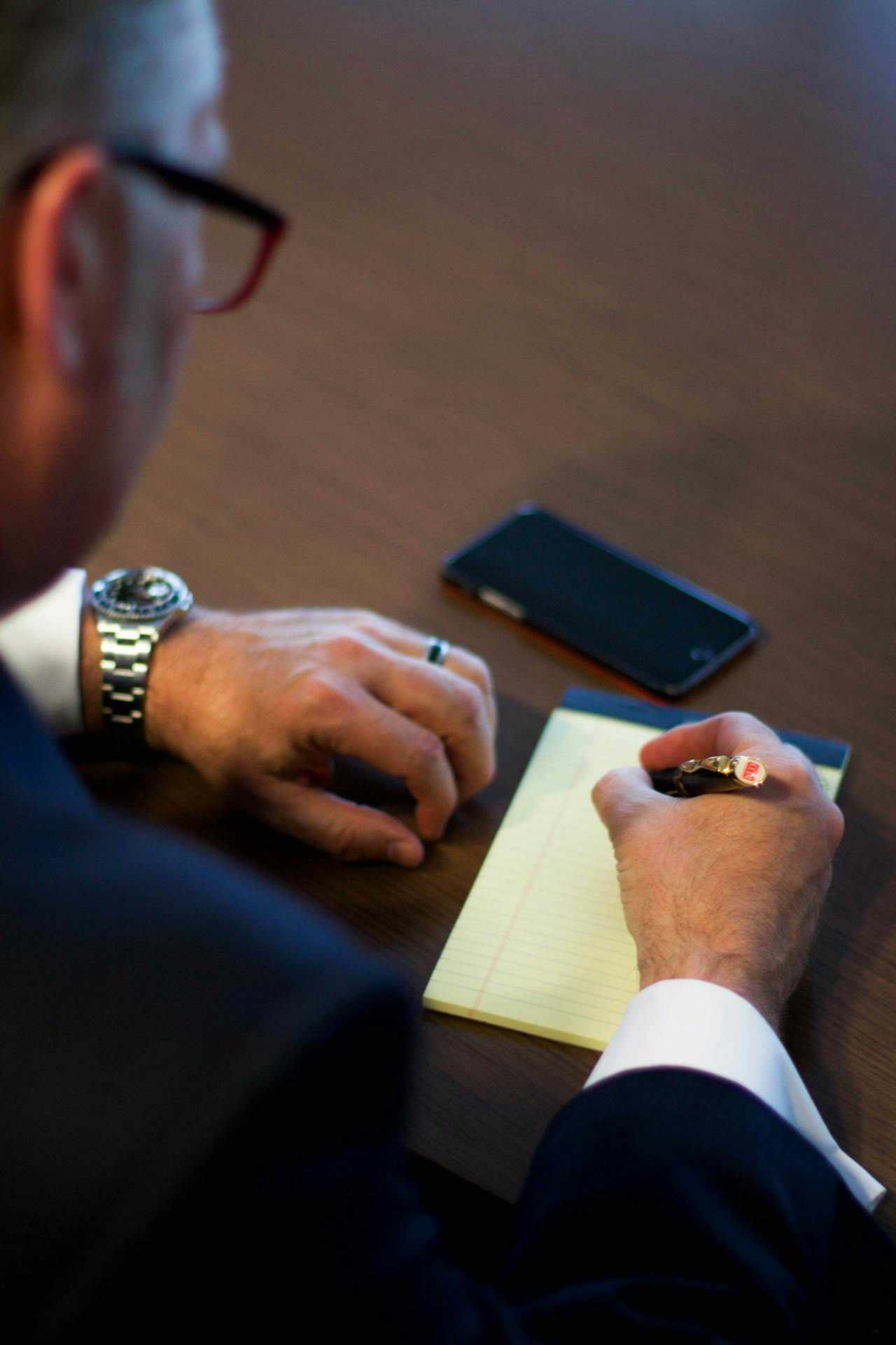 businessman-taking-notes-on-yellow-legal-pad